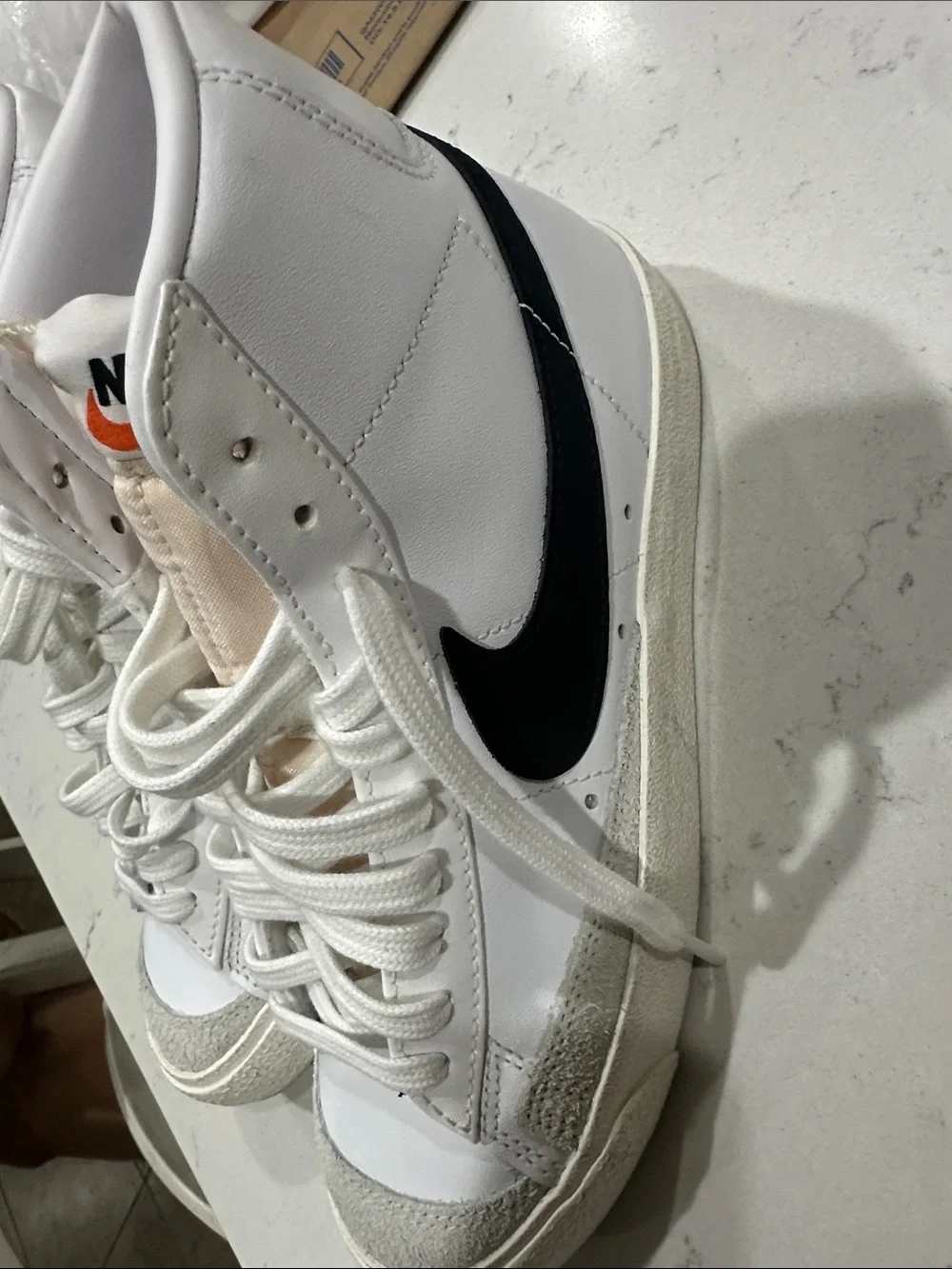 Nike White High-Top Sneakers with Orange Logo Accent